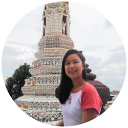 Photo of Katherine Truong, a UCR student with dark hair who is smiling at the camera standing in front of a sculpture